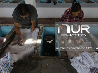 Two people are washing clothes at a community laundry in Santa Cruz Acalpixca, Xochimilco, Mexico City. (