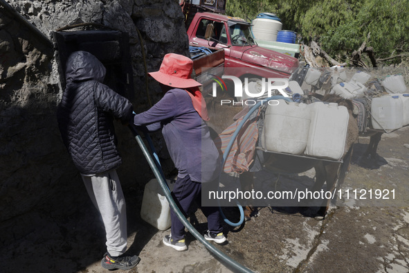 A person is filling water drums that are being transported by donkeys in Santa Cruz Acalpixca, Xochimilco, in Mexico City, due to a shortage...