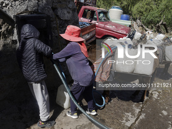 A person is filling water drums that are being transported by donkeys in Santa Cruz Acalpixca, Xochimilco, in Mexico City, due to a shortage...