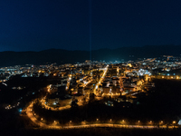 A blue light beam faced to the sky is seen in an aerial view in L'Aquila, Italy, on April 5th, 2024. On April 6th L'Aquila will commemorate...