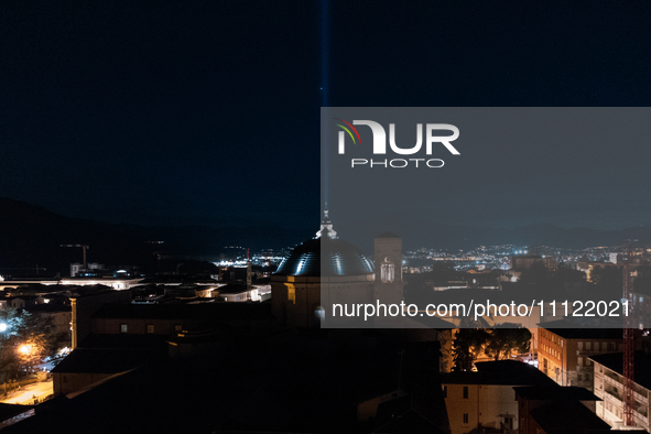 A blue light beam faced to the sky and San Bernardino church dome are seen in an aerial view in L'Aquila, Italy, on April 5th, 2024. On Apri...