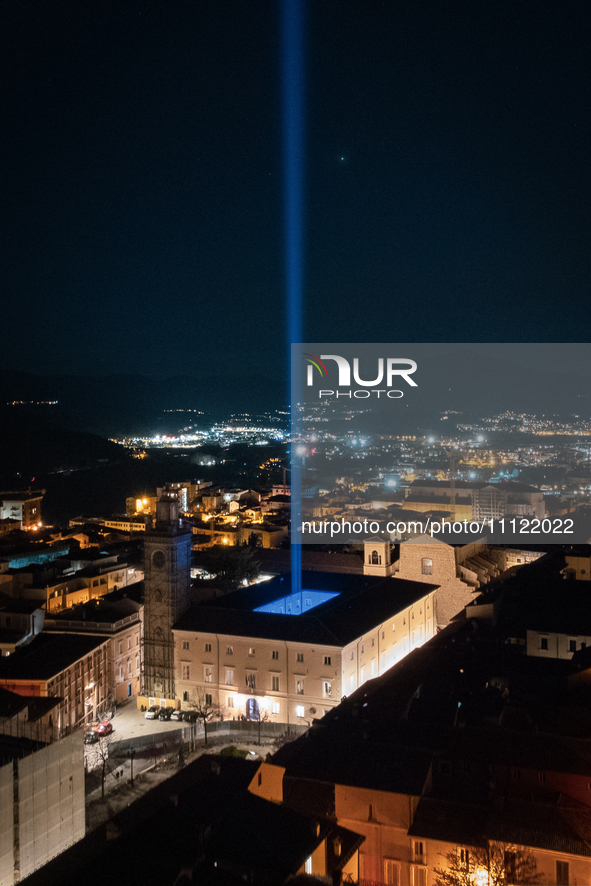 A blue light beam faced to the sky is seen in an aerial view in L'Aquila, Italy, on April 5th, 2024. On April 6th L'Aquila will commemorate...