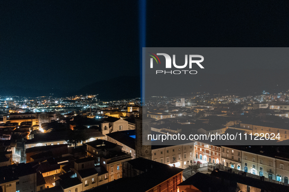 A blue light beam faced to the sky is seen in an aerial view in L'Aquila, Italy, on April 5th, 2024. On April 6th L'Aquila will commemorate...