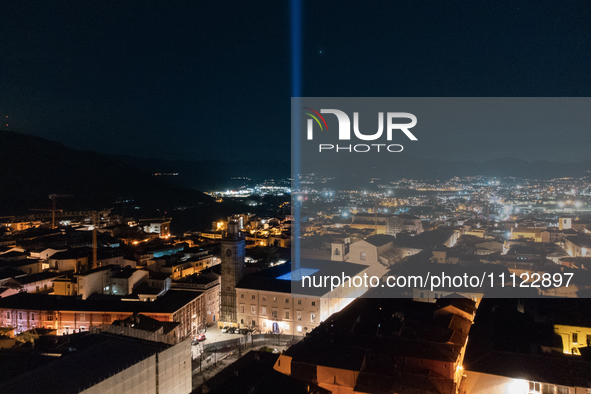 A blue light beam faced to the sky is seen in an aerial view in L'Aquila, Italy, on April 5th, 2024. On April 6th L'Aquila will commemorate...