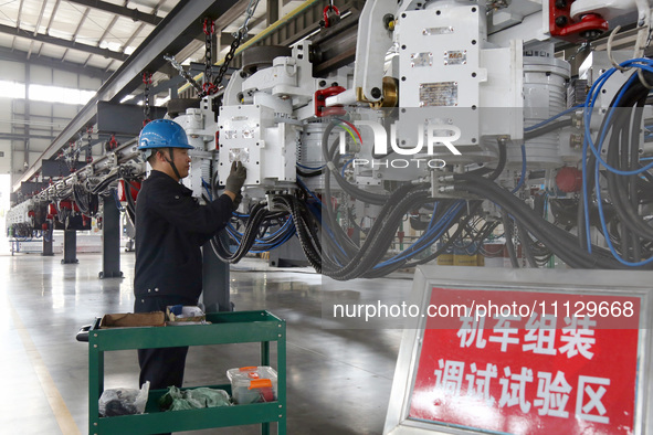 A technician is unveiling a newly assembled locomotive at a workshop of an equipment manufacturing company in Zaozhuang, China, on April 7,...