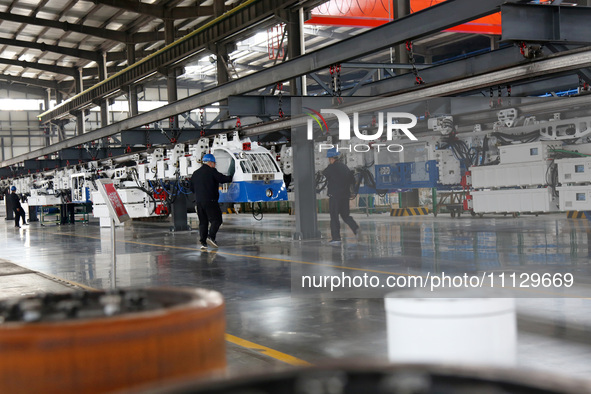 A technician is unveiling a newly assembled locomotive at a workshop of an equipment manufacturing company in Zaozhuang, China, on April 7,...