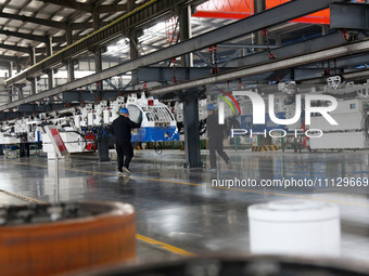 A technician is unveiling a newly assembled locomotive at a workshop of an equipment manufacturing company in Zaozhuang, China, on April 7,...