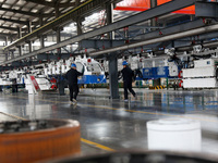 A technician is unveiling a newly assembled locomotive at a workshop of an equipment manufacturing company in Zaozhuang, China, on April 7,...