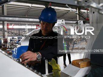 A technician is unveiling a newly assembled locomotive at a workshop of an equipment manufacturing company in Zaozhuang, China, on April 7,...