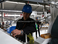 A technician is unveiling a newly assembled locomotive at a workshop of an equipment manufacturing company in Zaozhuang, China, on April 7,...