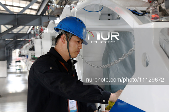 A technician is unveiling a newly assembled locomotive at a workshop of an equipment manufacturing company in Zaozhuang, China, on April 7,...