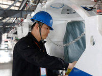 A technician is unveiling a newly assembled locomotive at a workshop of an equipment manufacturing company in Zaozhuang, China, on April 7,...