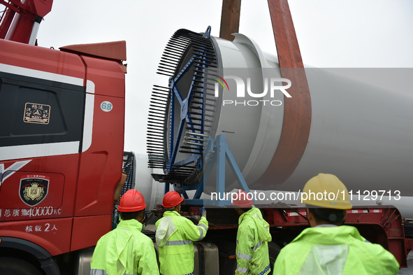 Workers are fixing wind power blades in Yangzhou, East China's Jiangsu province, on April 8, 2024. 