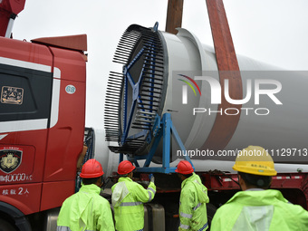 Workers are fixing wind power blades in Yangzhou, East China's Jiangsu province, on April 8, 2024. (