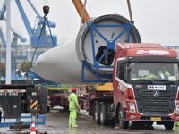 A crane is lifting wind turbine blades onto a special transport vehicle in Yangzhou, East China's Jiangsu province, on April 8, 2024. (