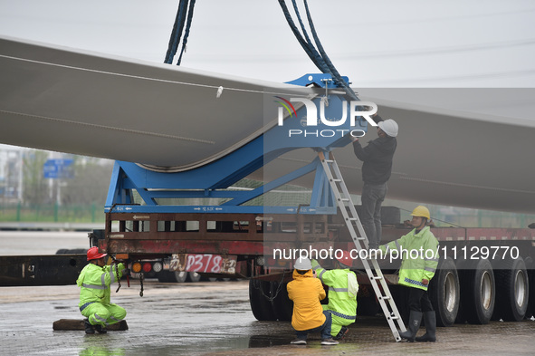 Workers are fixing wind power blades in Yangzhou, East China's Jiangsu province, on April 8, 2024. 