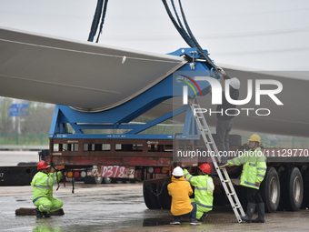 Workers are fixing wind power blades in Yangzhou, East China's Jiangsu province, on April 8, 2024. (