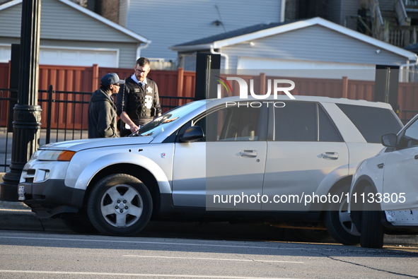 Vehicles are damaged at the crime scene where a 4-year-old boy is in critical condition after being shot in broad daylight in Chicago, Illin...