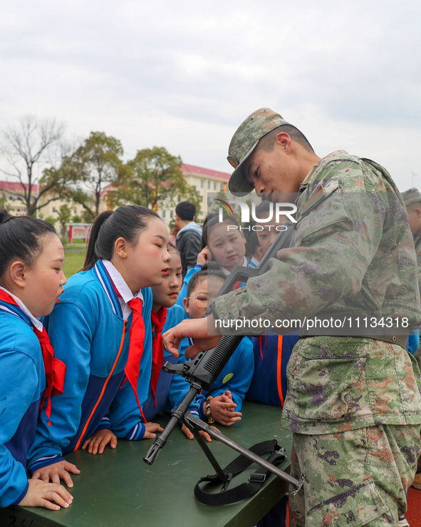 Students are experiencing individual weapons and equipment up close under the guidance of officers and soldiers in Yingtan, China, on April...