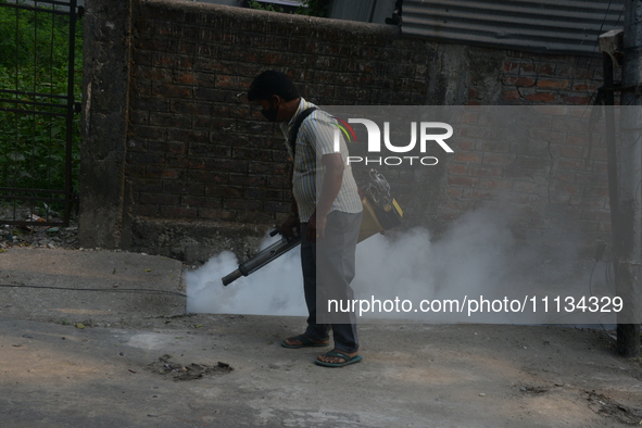 A municipal worker is fumigating a residential area as a preventive measure against disease-carrying mosquitoes in Siliguri, India, on April...