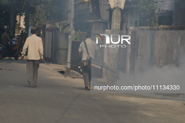 A municipal worker is fumigating a residential area as a preventive measure against disease-carrying mosquitoes in Siliguri, India, on April...