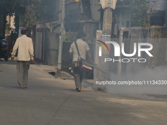 A municipal worker is fumigating a residential area as a preventive measure against disease-carrying mosquitoes in Siliguri, India, on April...