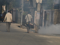 A municipal worker is fumigating a residential area as a preventive measure against disease-carrying mosquitoes in Siliguri, India, on April...