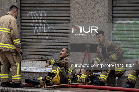 Firefighters are resting near the scene of the building fire in Hong Kong, on April 10, 2024. Today, a building fire in Hong Kong's Jordan D...