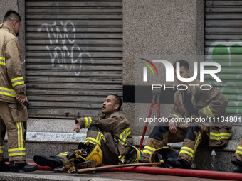 Firefighters are resting near the scene of the building fire in Hong Kong, on April 10, 2024. Today, a building fire in Hong Kong's Jordan D...