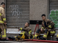 Firefighters are resting near the scene of the building fire in Hong Kong, on April 10, 2024. Today, a building fire in Hong Kong's Jordan D...