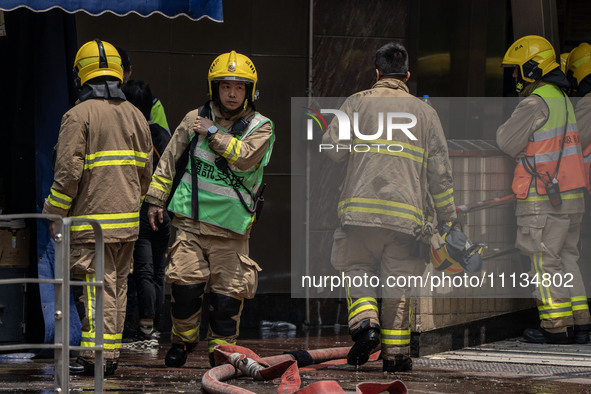 Firefighters are near the scene of a building fire in Hong Kong's Jordan District on April 10, 2024. The fire is resulting in 5 deaths and m...