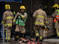 Firefighters are near the scene of a building fire in Hong Kong's Jordan District on April 10, 2024. The fire is resulting in 5 deaths and m...