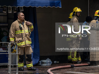 Firefighters are near the scene of a building fire in Hong Kong's Jordan District on April 10, 2024. The fire is resulting in 5 deaths and m...