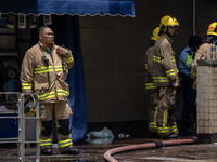 Firefighters are near the scene of a building fire in Hong Kong's Jordan District on April 10, 2024. The fire is resulting in 5 deaths and m...