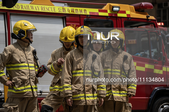 Firefighters are near the scene of a building fire in Hong Kong's Jordan District on April 10, 2024. The fire is resulting in 5 deaths and m...