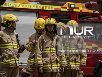 Firefighters are near the scene of a building fire in Hong Kong's Jordan District on April 10, 2024. The fire is resulting in 5 deaths and m...