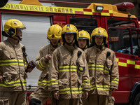 Firefighters are near the scene of a building fire in Hong Kong's Jordan District on April 10, 2024. The fire is resulting in 5 deaths and m...