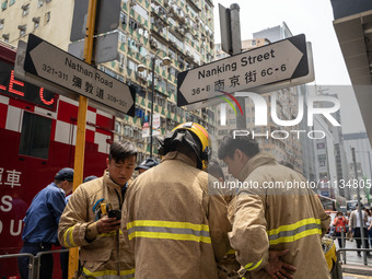 Firefighters are near the scene of a building fire in Hong Kong's Jordan District on April 10, 2024. The fire is resulting in 5 deaths and m...