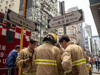 Firefighters are near the scene of a building fire in Hong Kong's Jordan District on April 10, 2024. The fire is resulting in 5 deaths and m...