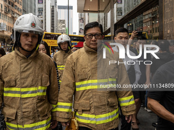 Hong Kong Secretary for Security Chris Tang Ping-keung is dressed in a firefighter's uniform at the scene of the building fire in Hong Kong'...