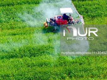 A farmer is driving a plant protection machine to control wheat scab in Sanlian village, Jinxi town, Kunshan City, China, on April 10, 2024....