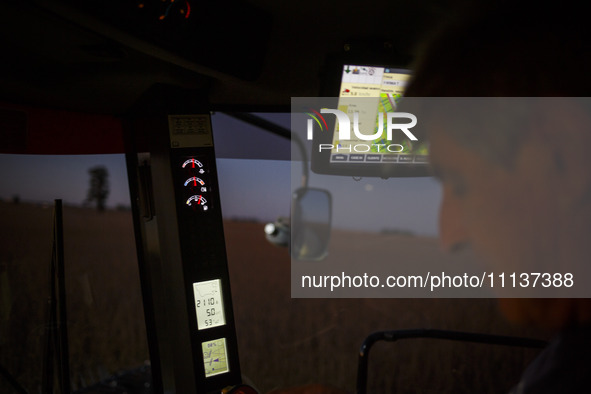 Walter is driving the combine at dusk, harvesting a soybean field. 