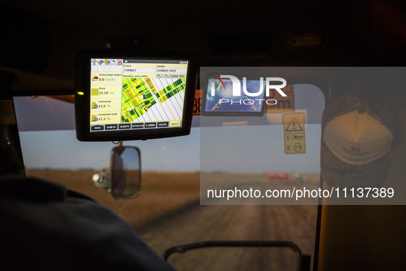 Digital monitors are being seen inside the cabin of the combine harvester. 