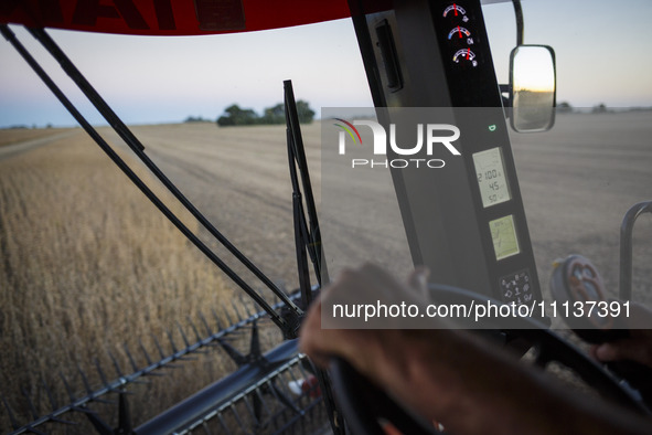 The reel of the combine is being seen from inside the driver's cabin. 