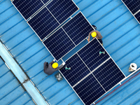 Workers are installing solar photovoltaic panels on the roof of a factory in Haian, Jiangsu Province, China, on April 11, 2024. (