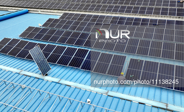 Workers are installing solar photovoltaic panels on the roof of a factory in Haian, Jiangsu Province, China, on April 11, 2024. 