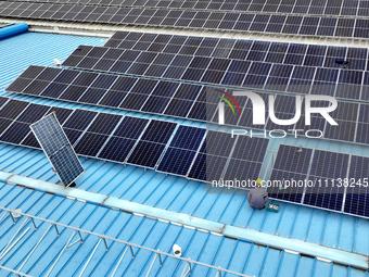 Workers are installing solar photovoltaic panels on the roof of a factory in Haian, Jiangsu Province, China, on April 11, 2024. (