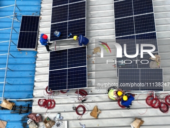 Workers are installing solar photovoltaic panels on the roof of a factory in Haian, Jiangsu Province, China, on April 11, 2024. (