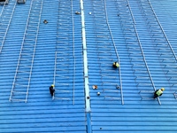 Workers are installing solar photovoltaic panels on the roof of a factory in Haian, Jiangsu Province, China, on April 11, 2024. (