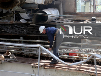 A worker is inspecting the damage at the Kharkiv Combined Heat and Power Plant (CHP) in the Kharkiv Region, northeastern Ukraine, on April 1...